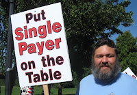 a man holding a sign which reads 'Put Single Payer on the Table'